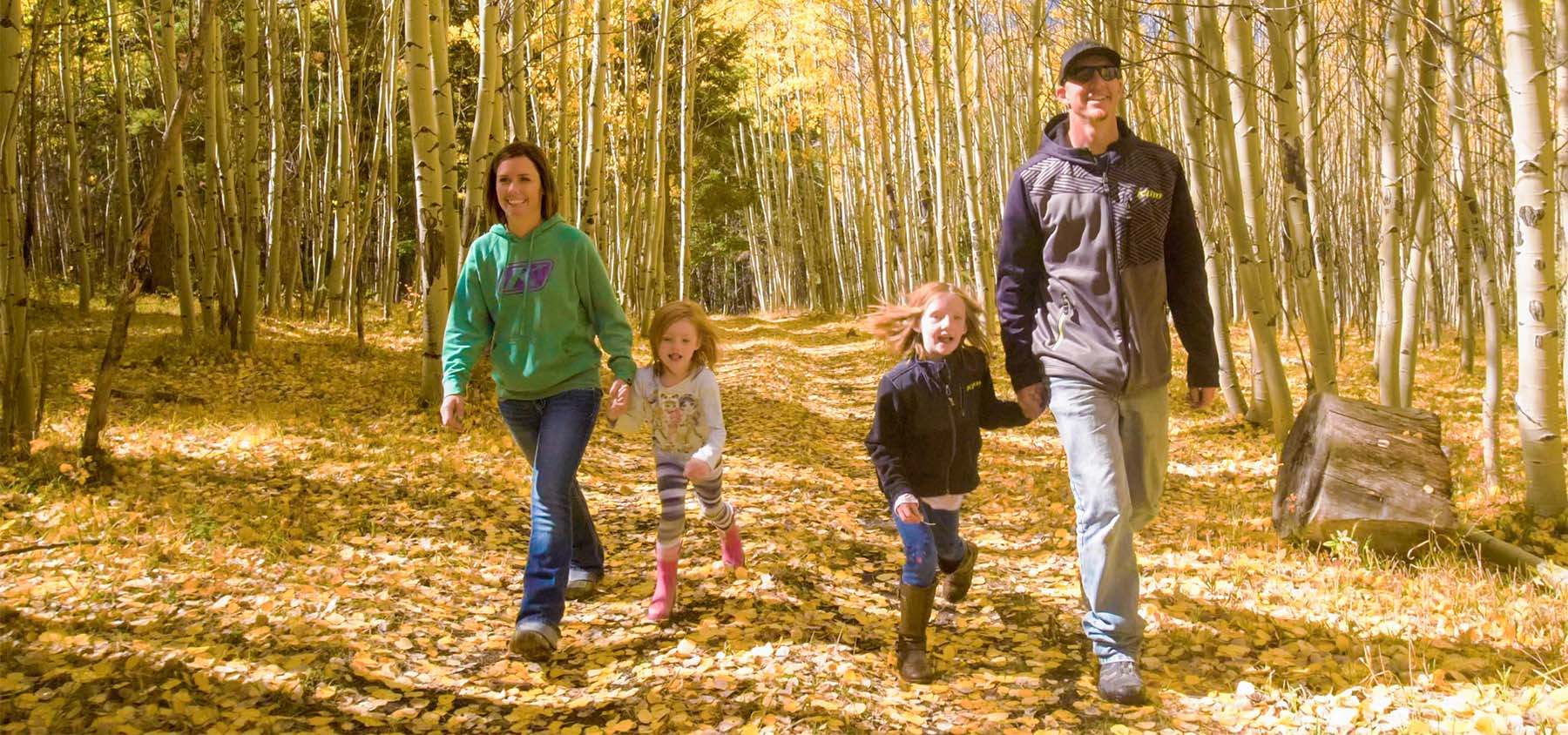 Family walking through the Colorado fall leaves